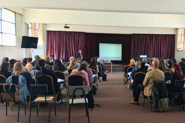 Participantes en el encuentro, sentados, escuchando activamente.