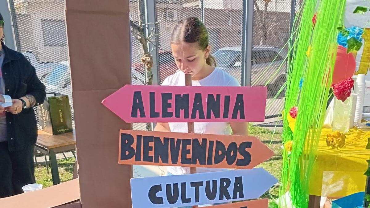 Estudiante en presencia del cartel de binevenida a la muestra. 