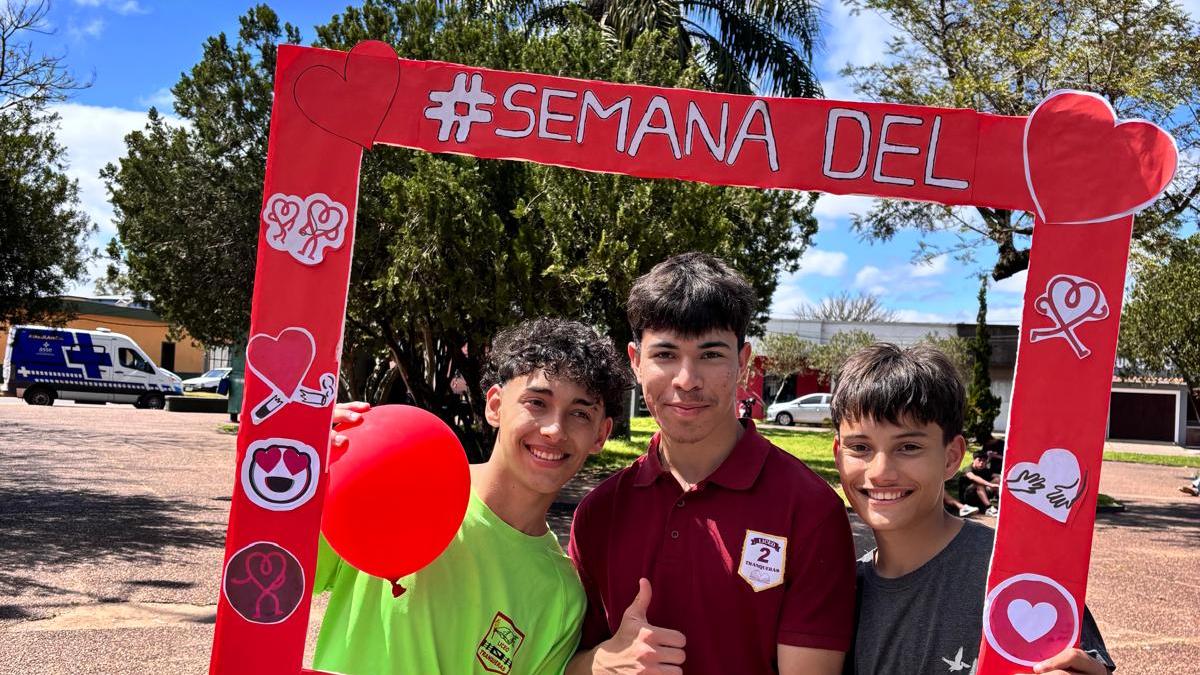 Material del Liceo de Tranqueras. Estudiantes sacándose una foto con un marco realizado por ellos para poder interactuar durante la edición. 