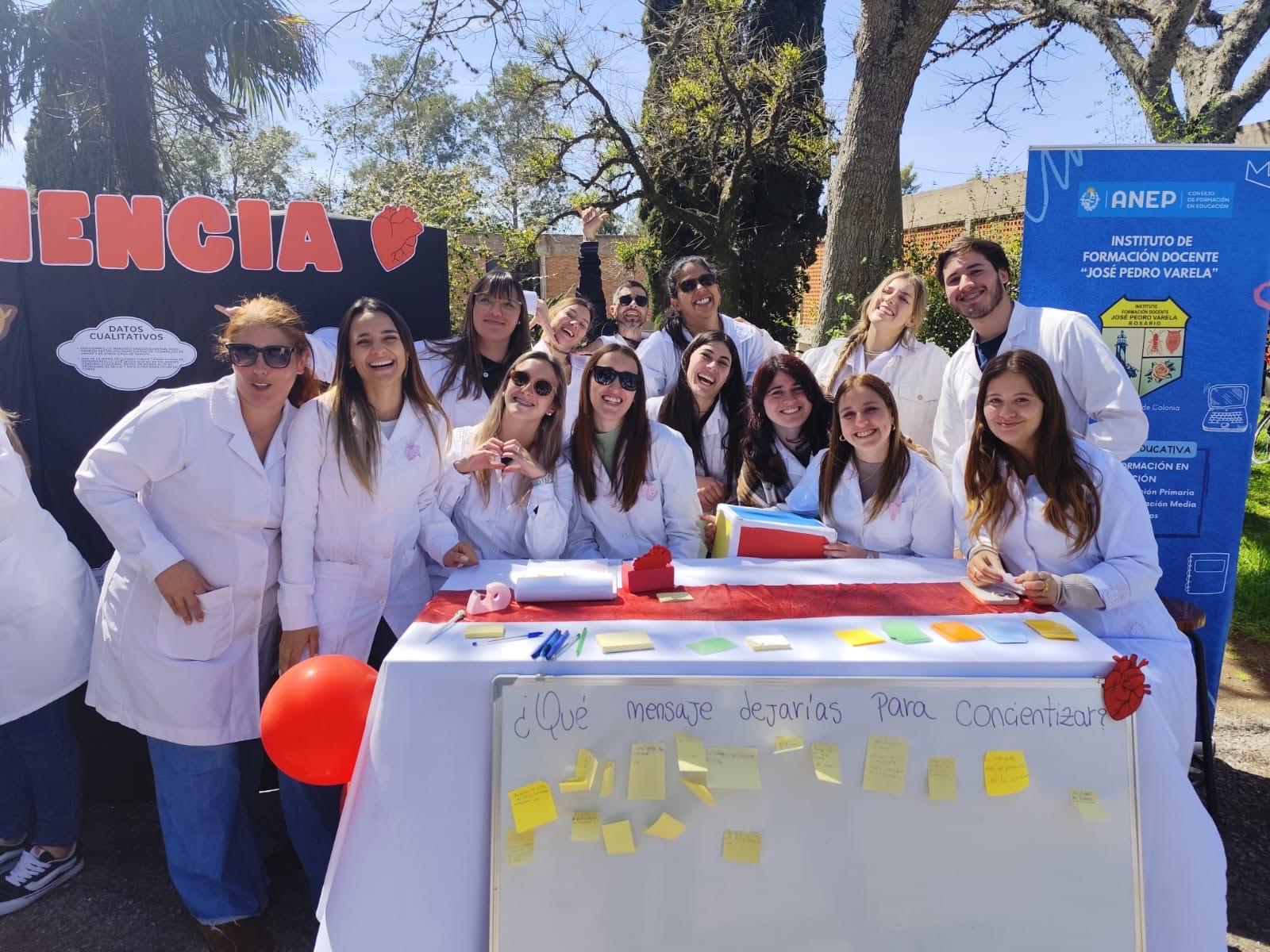 Material del Liceo AIUC. Docentes y estudiantes en el estand, celebrando la edición. 