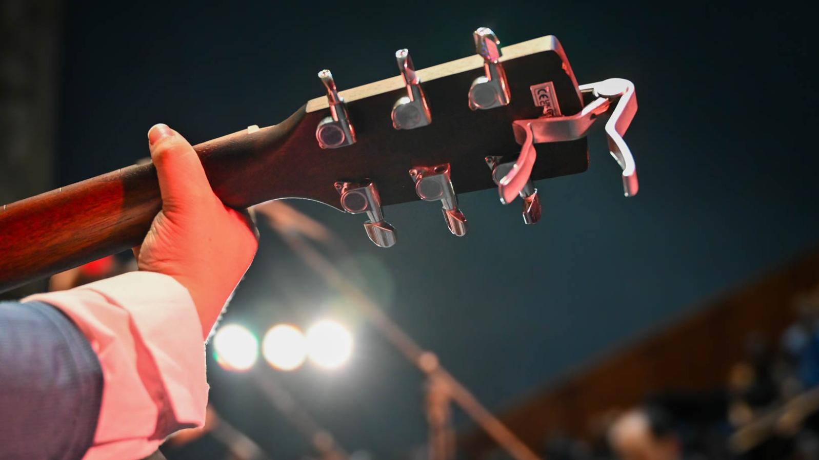 Estudiante tocando acorde de la guitarra.